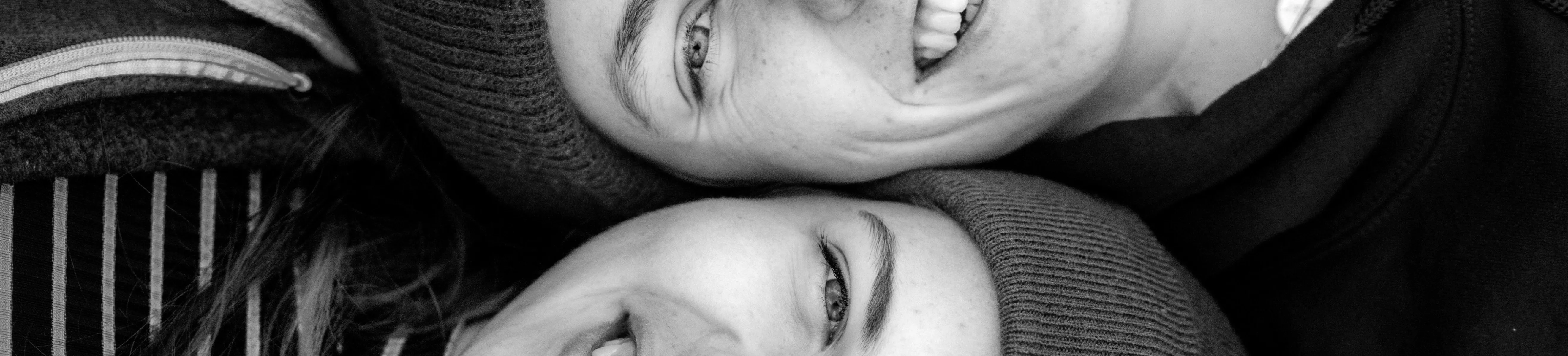 Zwei Frauen liegen Kopf an Kopf und lächeln